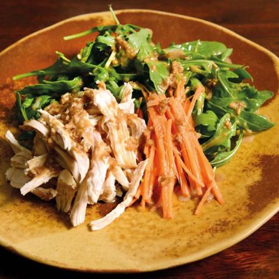 Chicken salad with rucula, carrot and homemade sesame sauce on top. Chicken is cooked at low temperature