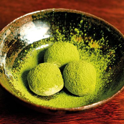 Homemade truffles made of black chocolate and a bit of sake covered with green tea powder